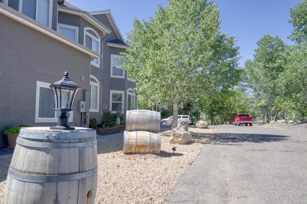 A residential street with a house, wooden barrels, and a red truck. - Castle Creek B&B (Grand Junction)
