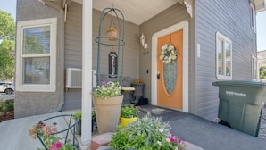 A house with a porch, a welcome sign, a door with a floral wreath, and a trash can. - Castle Creek B&B (Grand Junction)