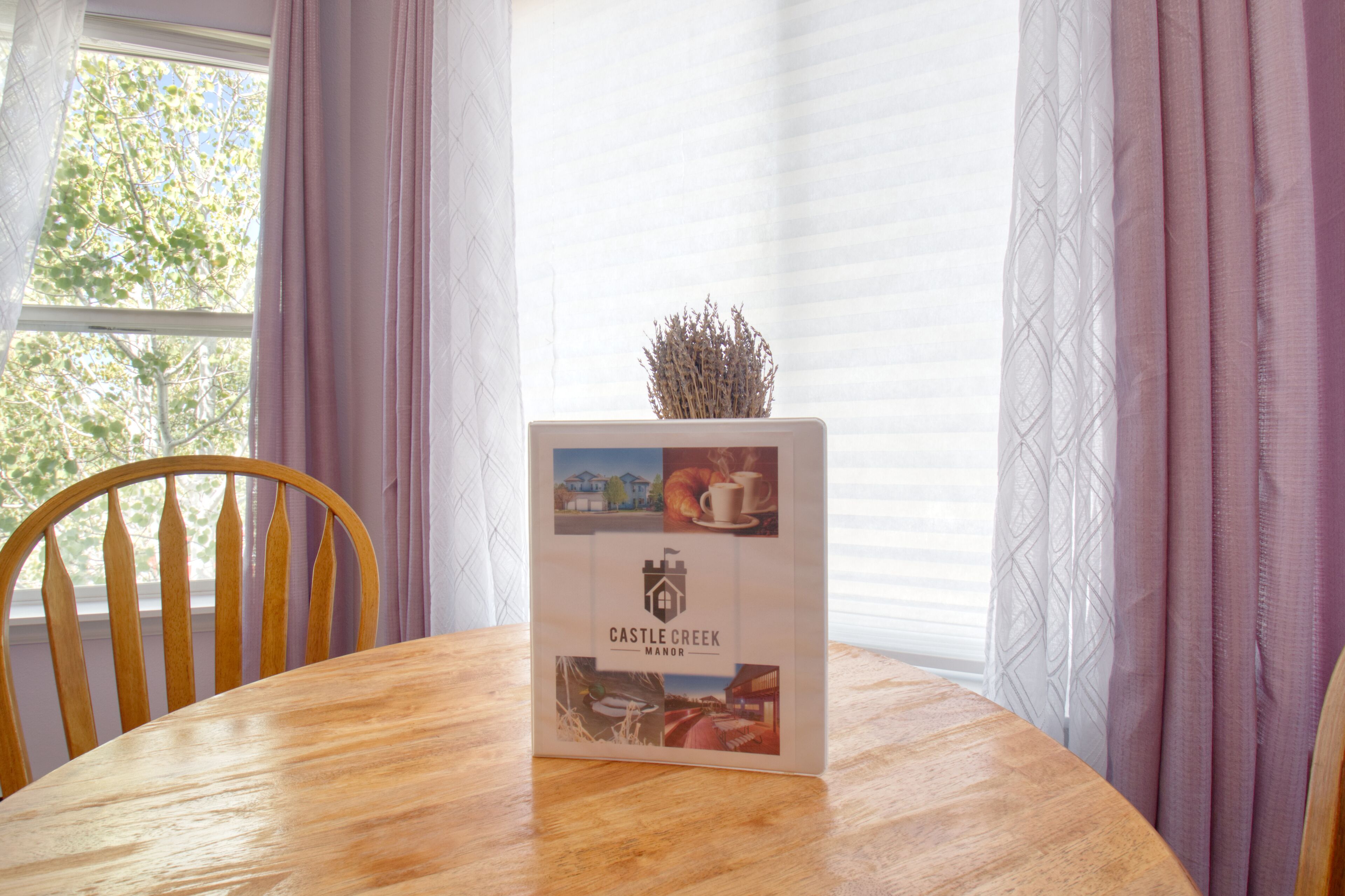 A wooden table with a brochure for Castle Creek Manor.