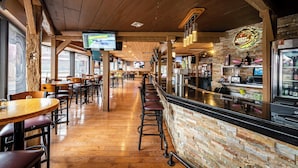 Ein Restaurantinneres mit Holzböden, einer Bar und einer Steinwand.