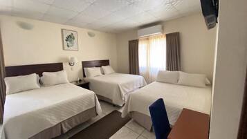Ein Hotelzimmer mit zwei Betten, einem Schreibtisch und einem Stuhl.