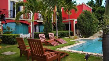 Relax by the serene pool surrounded by lush greenery and enjoy the scenic views from the balcony.