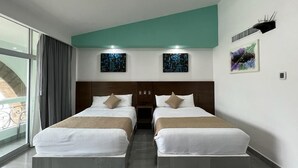 Una camera d'albergo con due letti, una finestra con tende e opere d'arte alle pareti.