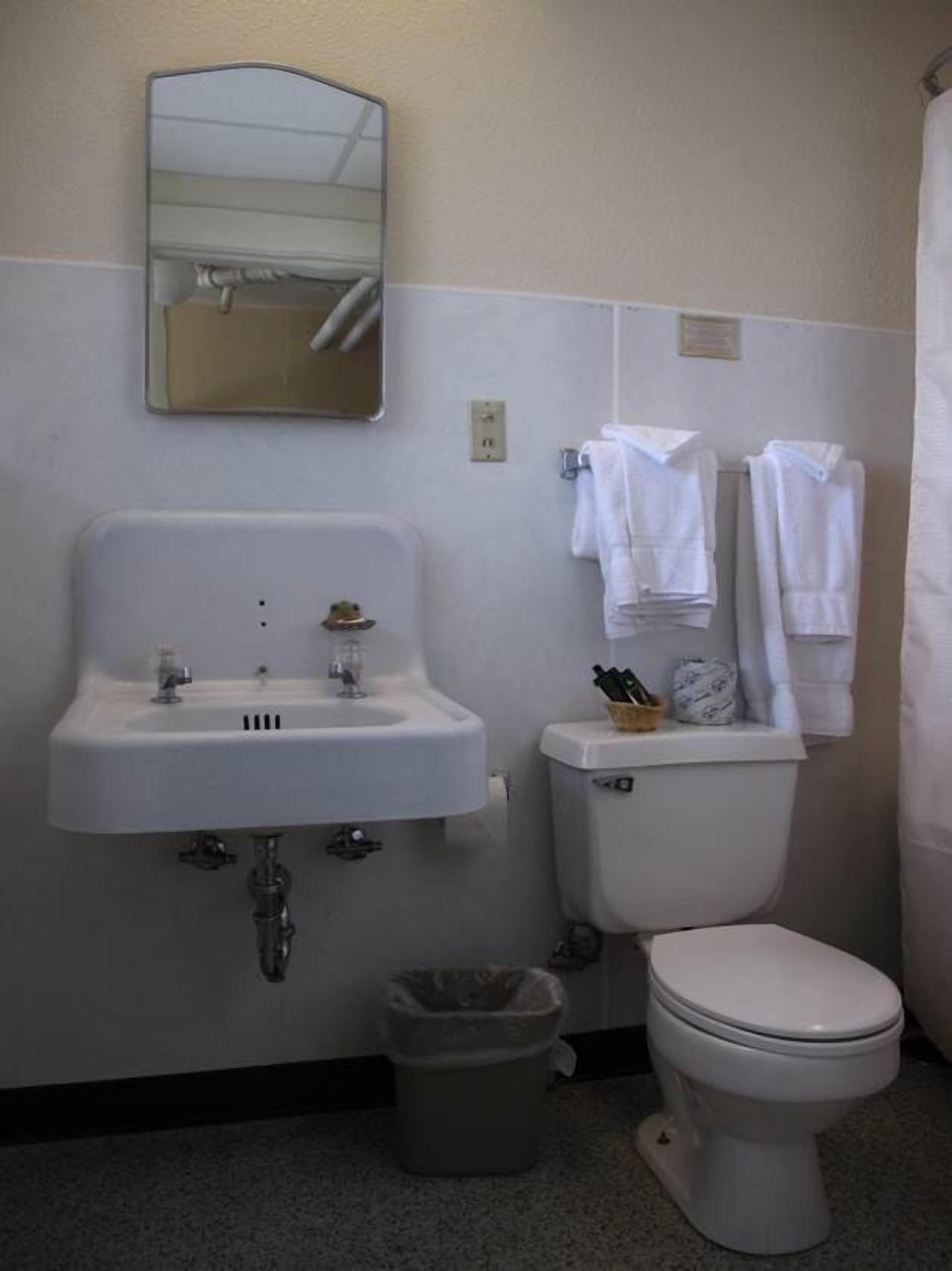 Ein Badezimmer mit Waschbecken, Toilette und Spiegel.