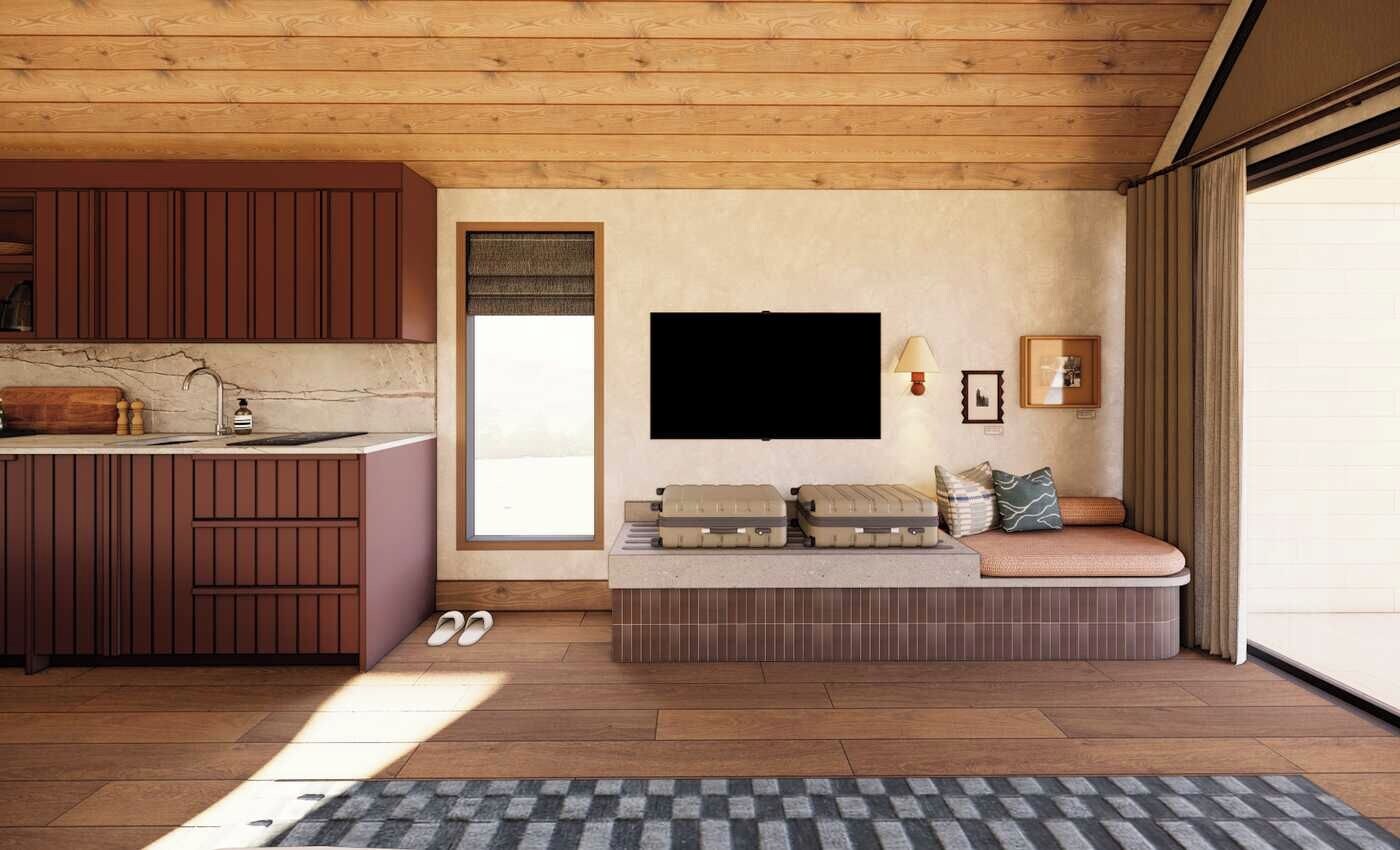 Una habitación con techo de madera, un banco empotrado con cojines, un televisor de pantalla plana en la pared y una ventana con cortinas.