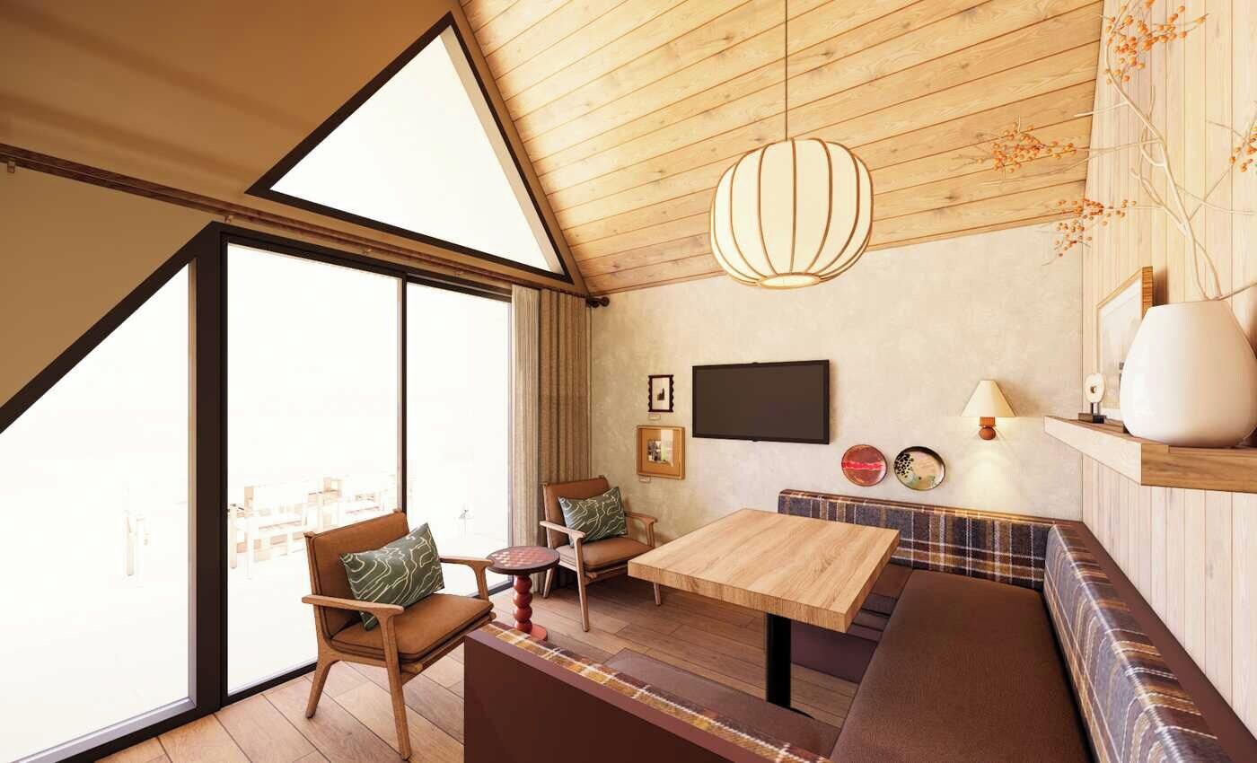 A room with a wooden ceiling, a large window, a wooden table, a bench, and a hanging light fixture.