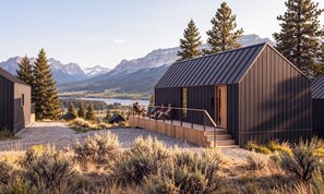 A cabin with a deck overlooking a lake and mountains. - St. Mary Village (Browning)