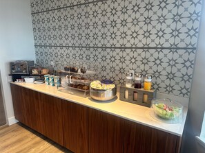 A breakfast buffet with various food items, a toaster, and a fruit bowl. - Cannery Pier Hotel & Spa (Astoria)