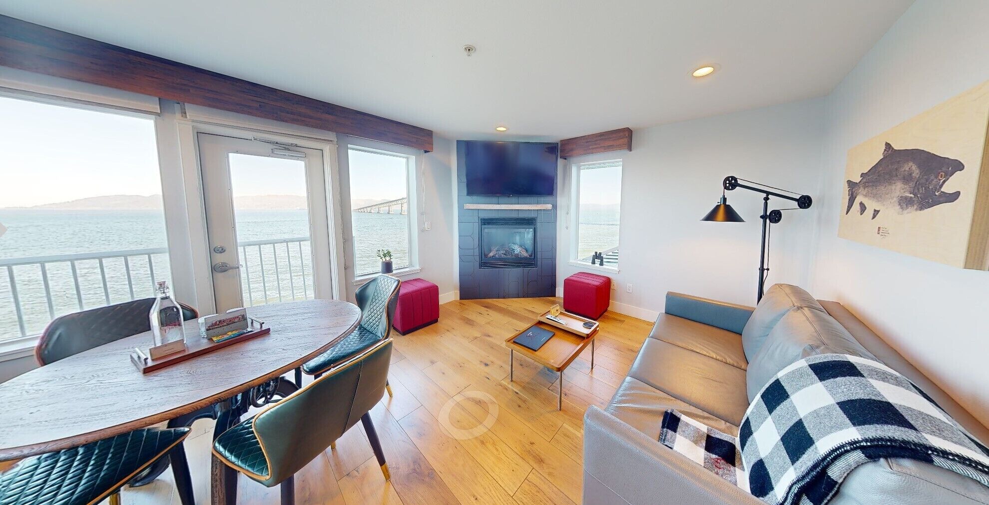 A modern living room with a fireplace, a dining area, and a sofa.