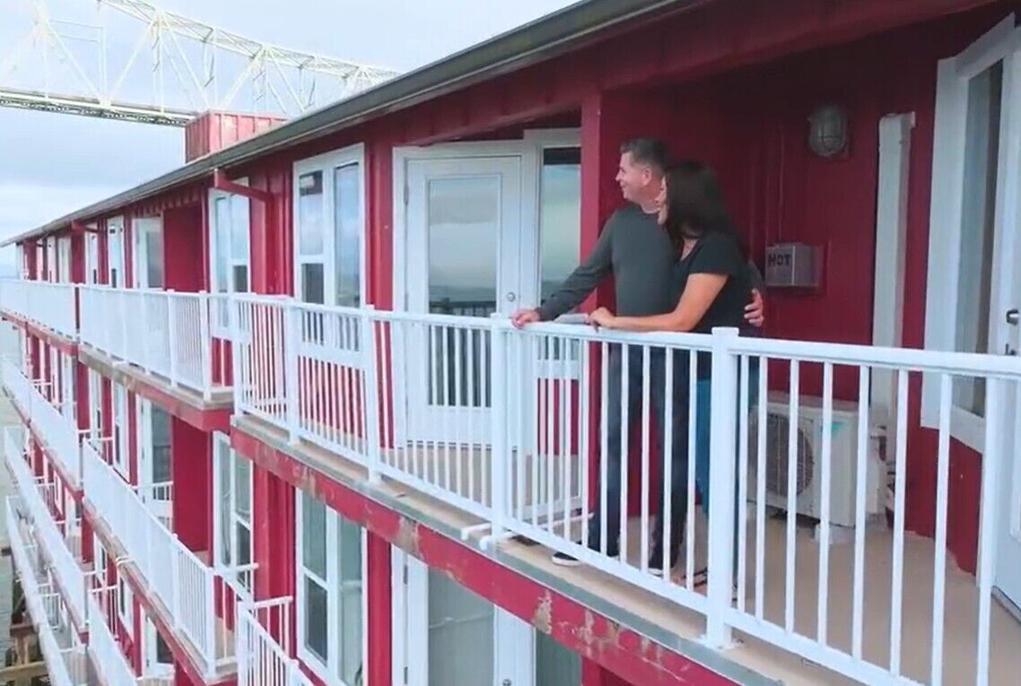 A red building with white railings and a white door.