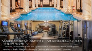 A swimming pool and gymnasium in Harbourview Hotel, with exercise equipment and a mirrored wall. - Rocks Hotel (Macau)