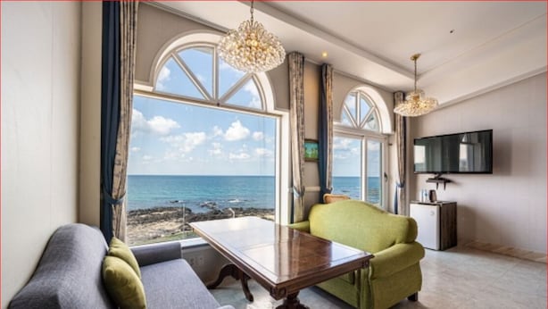 Un salon avec vue sur la mer, un téléviseur et une table à manger.