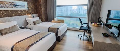 Une chambre d’hôtel avec deux lits, un bureau, une chaise et une grande fenêtre donnant sur la ville.