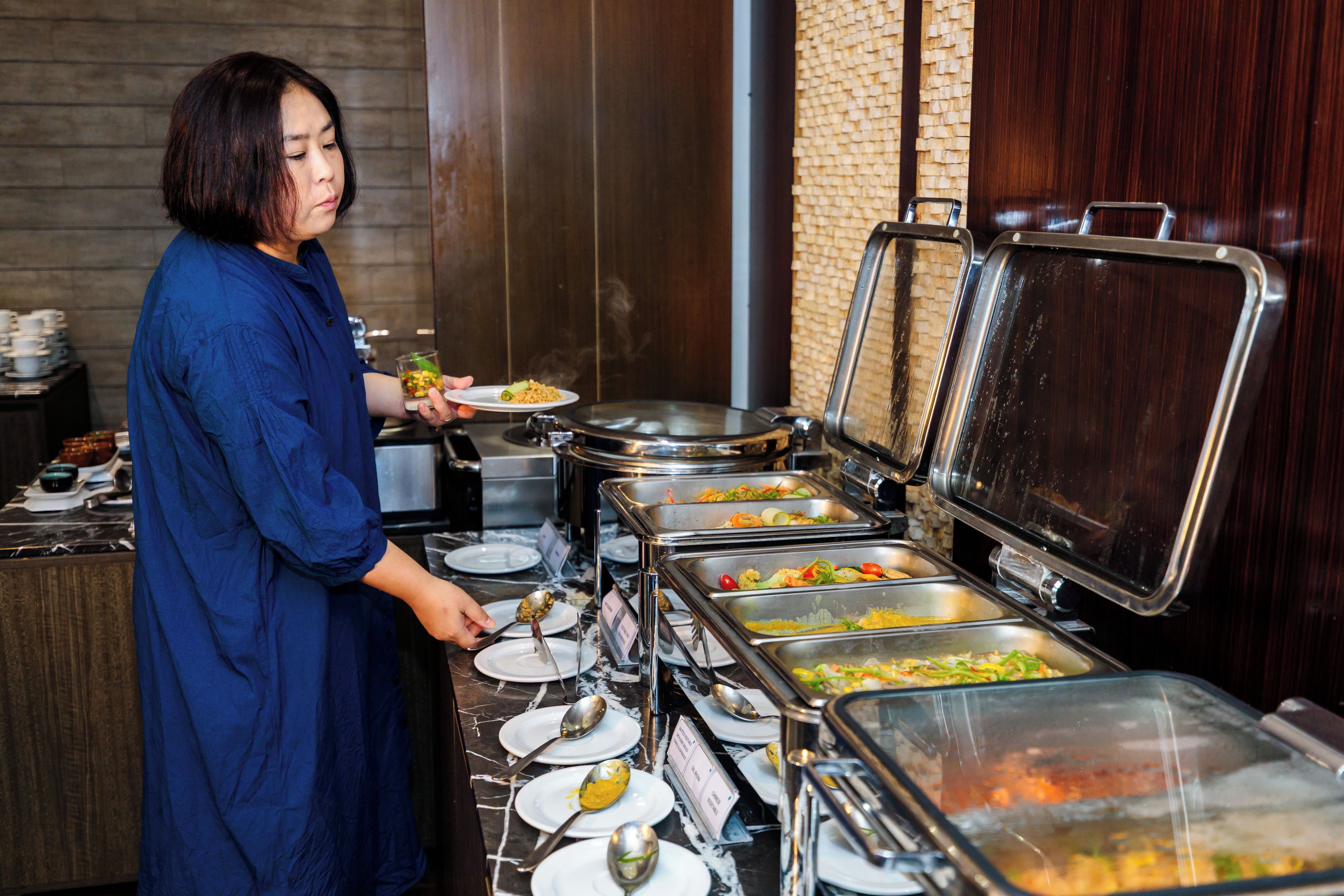 A buffet setup with multiple food dispensers and plates.