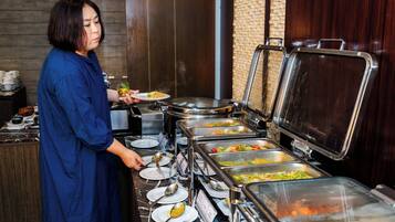 A buffet setup with multiple food dispensers and plates.