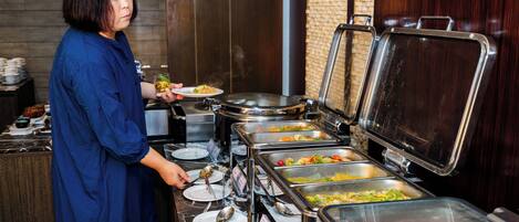 A buffet setup with multiple food dispensers and plates.