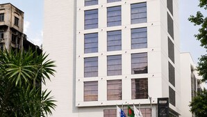 Un edificio moderno y alto de hotel con un llamativo letrero que dice 'Best Western PLUS Maple Leaf'.