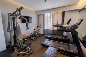 A home gym with a treadmill, stationary bike, and weight machine. - Best Western Plus Maple Leaf (Dhaka)