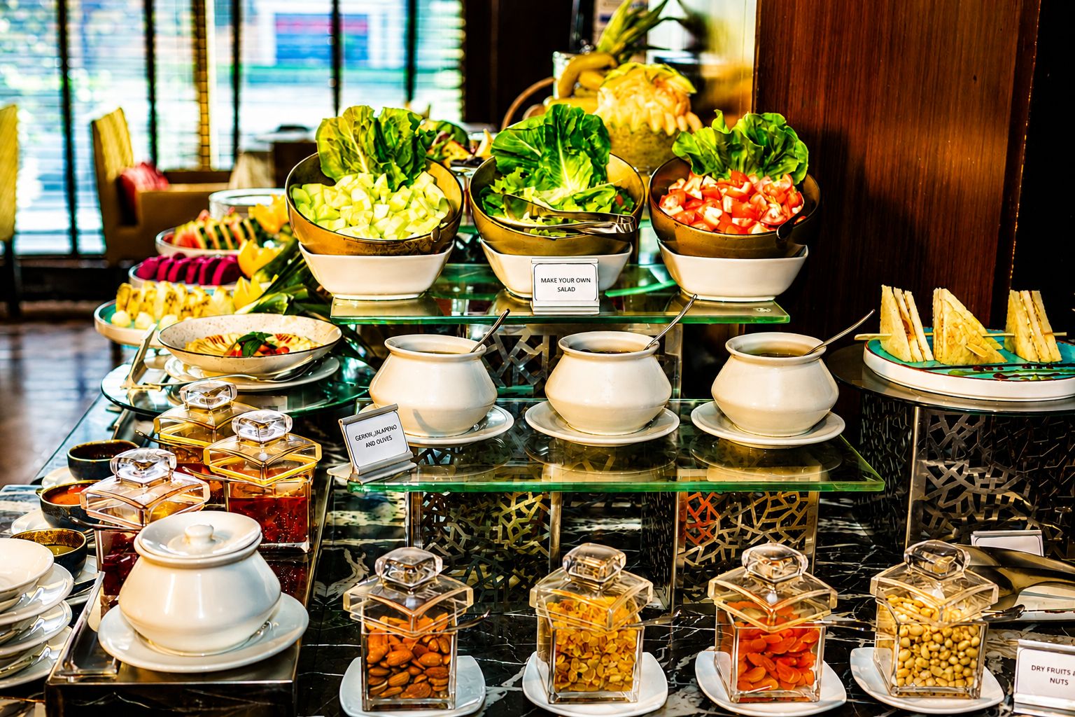 A buffet with various food options including salads, fruits, and nuts.