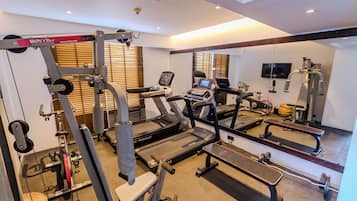 A gym with treadmills, weight machines, and a bench.