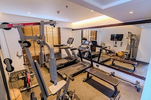 A gym with treadmills, weight machines, and a bench.