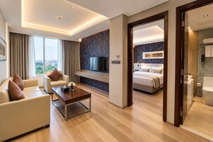 Una habitación de hotel moderna con sala de estar, dormitorio y baño.