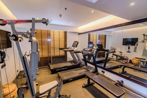 A gym with treadmills, a weight bench, and exercise equipment. - Best Western Plus Maple Leaf (Dhaka)