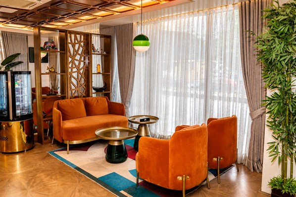 Una sala de estar moderna con un sofá, sillones, una mesa de centro y un aparador decorativo.
