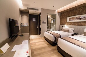 A hotel room with two beds, a desk with a television, and a shower area. - Best Western Plus Maple Leaf (Dhaka)