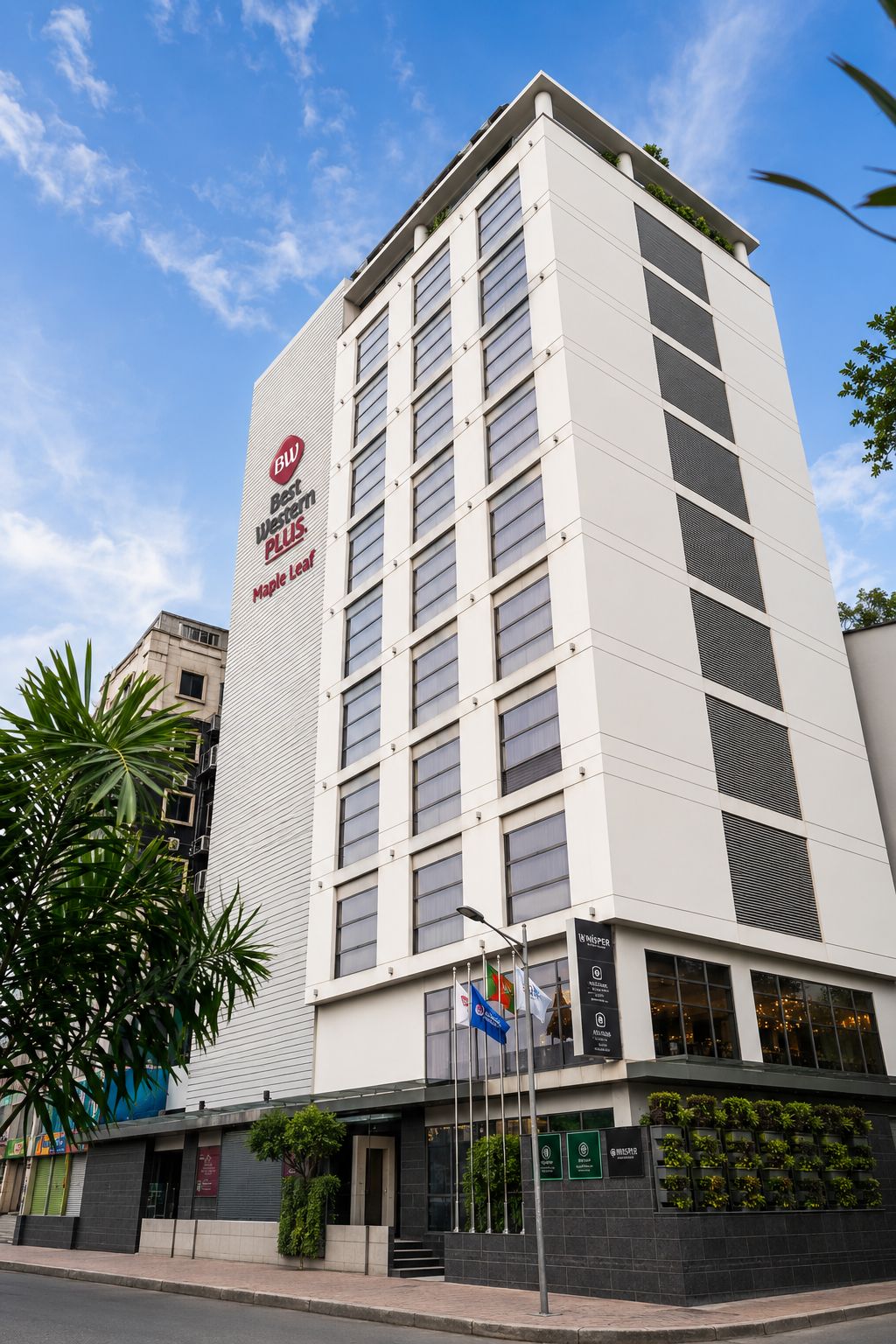 Een hoog, modern gebouw met een opvallend bord met de tekst 'Best Western PLUS Maple Leaf'.