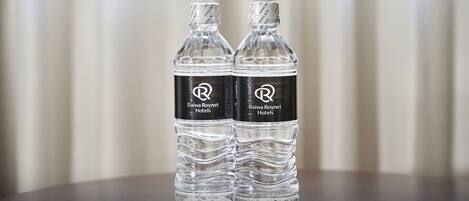 Two clear water bottles with labels on a table.
