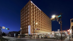 Un hotel Daiwa Roynet con un diseño moderno, que presenta una cuadrícula de ventanas y una señalización destacada en la parte superior.