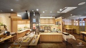 Un restaurante con interiores de madera, una barra de sushi y una zona de bar con carta.