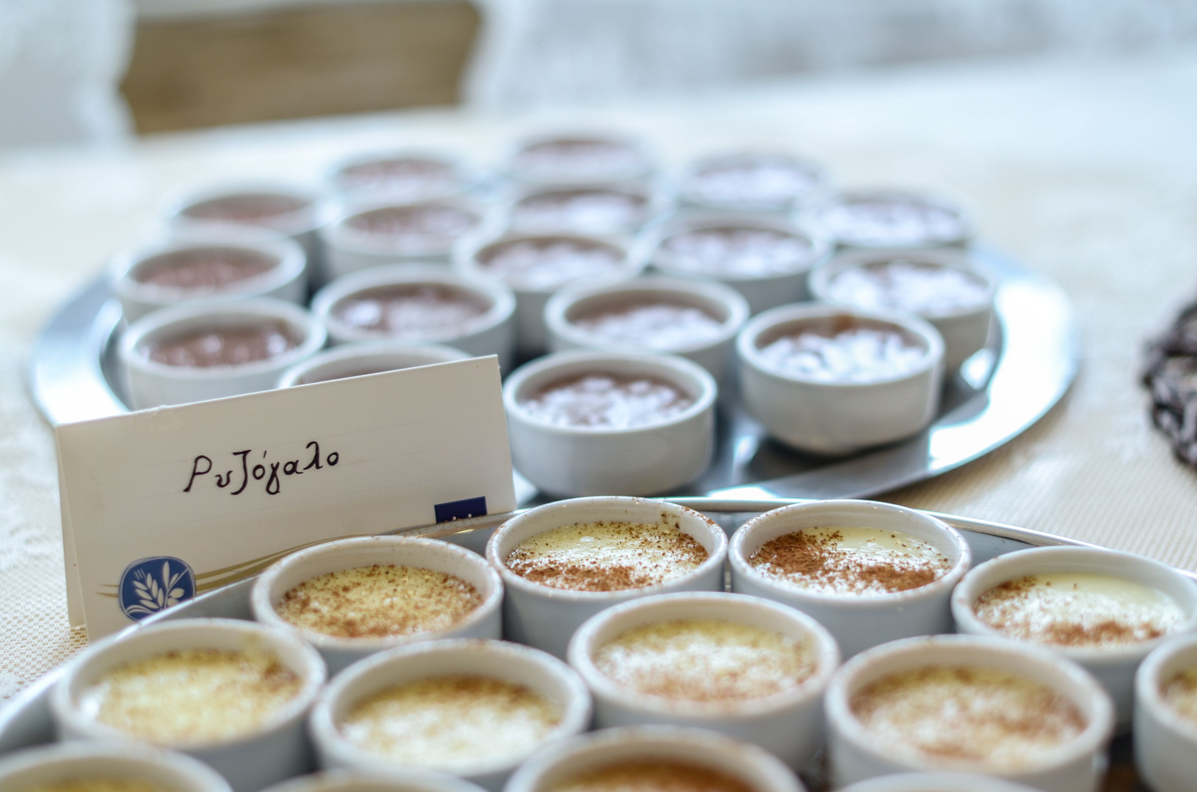 A tray of dessert cups with a sign reading "Pujolano".