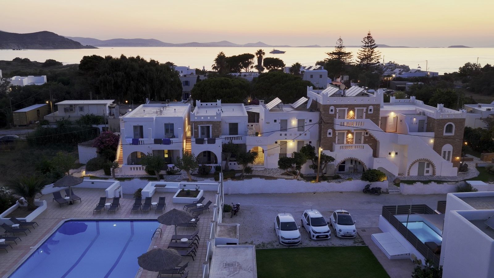 A resort with a swimming pool, multiple villas, and a view of the sea.