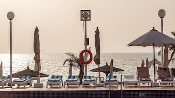 On the beach, white sand, sun-loungers, beach umbrellas