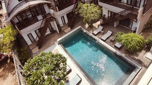 A resort with multiple bungalow-style buildings, a central swimming pool, and lush greenery. - Naturela Uluwatu (Pecatu)