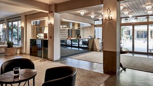 A spacious lobby with a reception desk, seating area, and large windows. - Rouge Hotel International (Cervia)