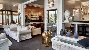 A modern interior with a seating area, a bar, and a dining space. - Rouge Hotel International (Cervia)