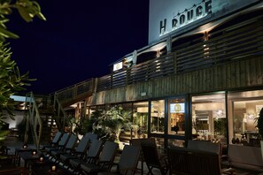Un hotel con mesas al aire libre y un letrero que dice "H. ROUGE".