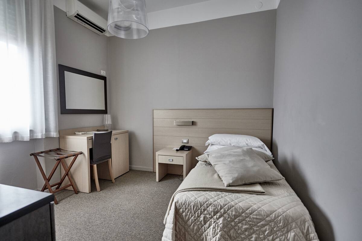 Une chambre d’hôtel moderne équipée d’un lit, d’un bureau, d’une chaise et d’une petite table.