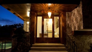 A stone building with a wooden staircase leading to a door with glass panels. - Hotel Villa Clementina (Scafati)