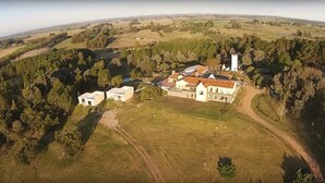An aerial view of a rural property with a large house, a tower, and surrounding fields. - St Michel Wellness Hotel (Maldonado)