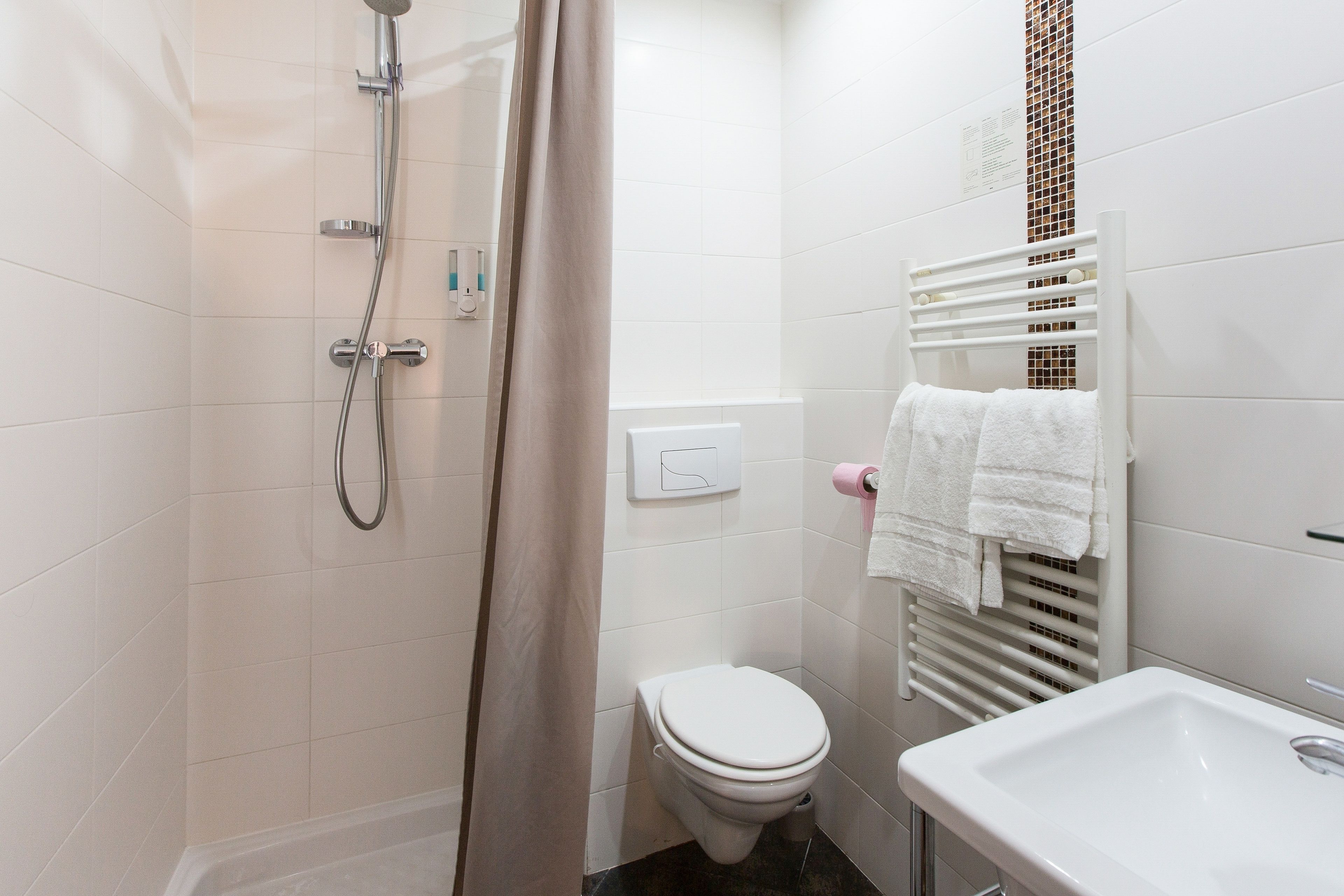 A bathroom with a shower, toilet, and sink.