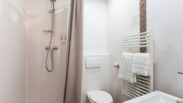 A bathroom with a shower, toilet, and sink.