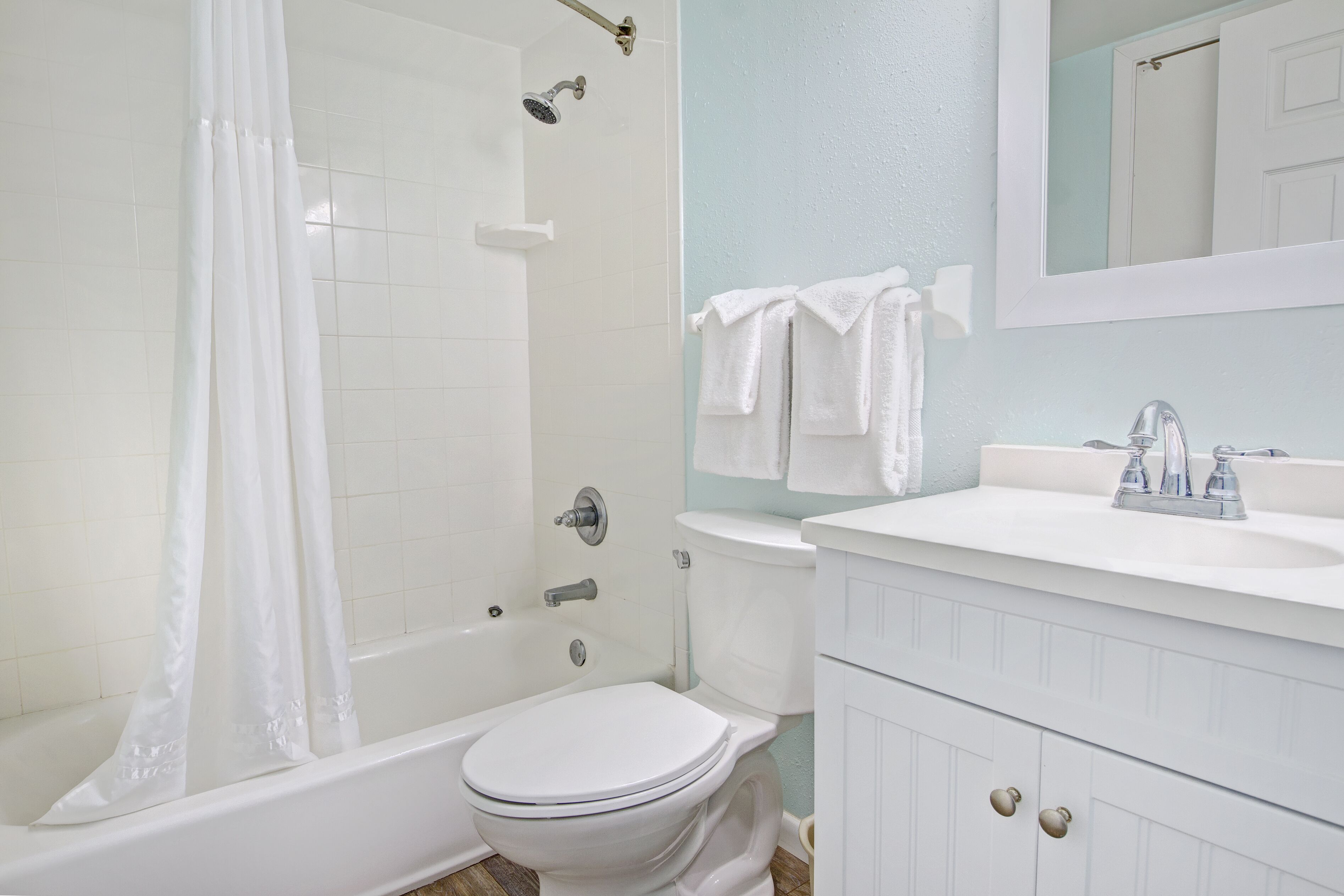 A bathroom with a bathtub, toilet, and sink.