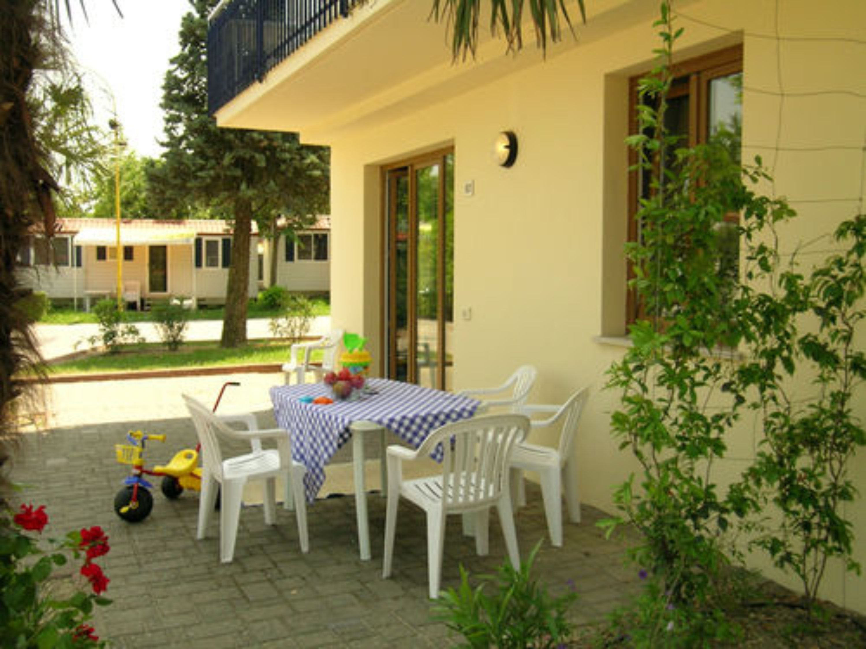 A patio with a table and chairs, a bicycle, and a small garden area.