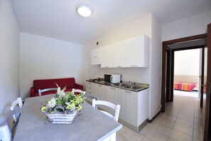 Apartment, 2 Bedrooms (Ibisco) | Private kitchen | Fridge, stovetop, coffee/tea maker, cookware/dishes/utensils - Camping Bella Italia (Peschiera del Garda)