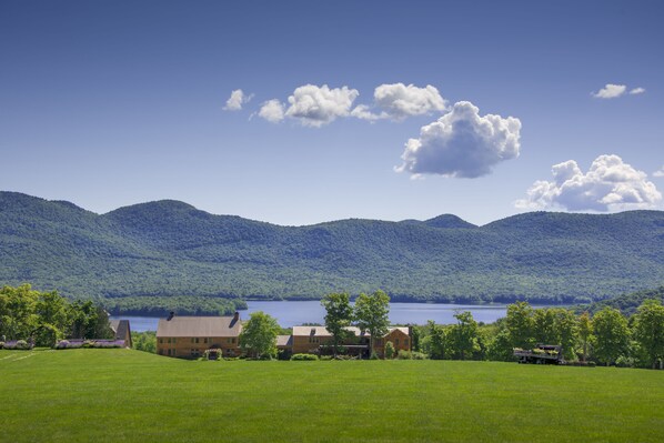 A house with a large lawn and a lake in the background. - The Mountain Top Inn & Resort (Chittenden)