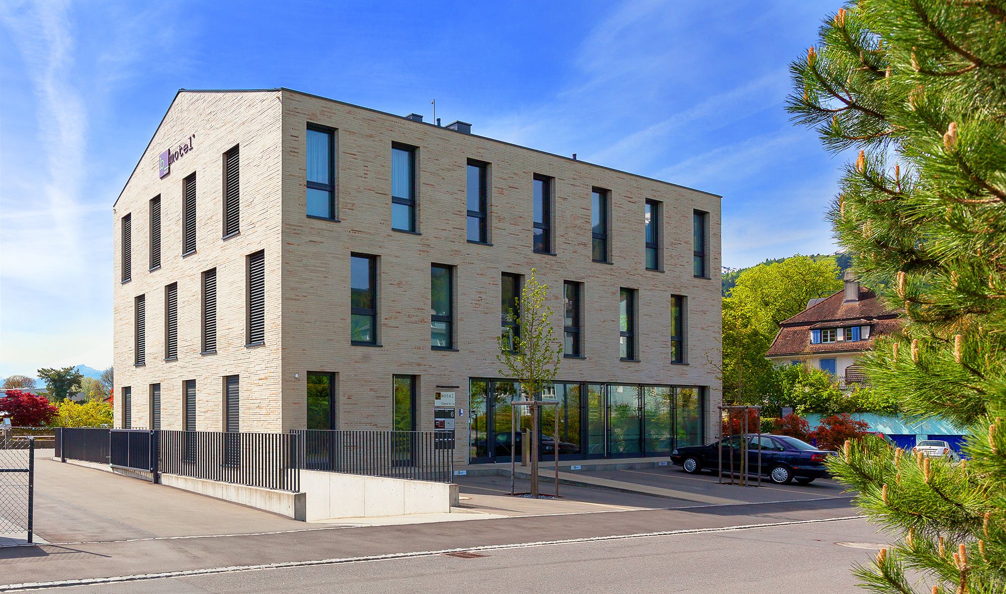 Ein modernes Hotel mit flachem Dach, vielen Fenstern und einem gut sichtbaren Eingang.